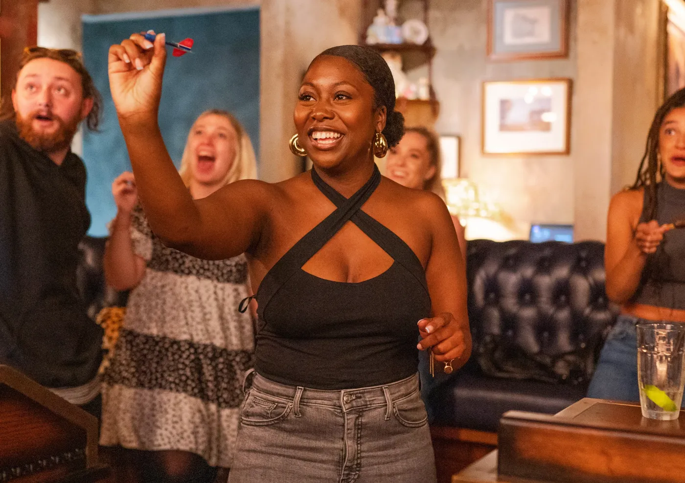 group playing social darts with a girl throwing a dart at flight club