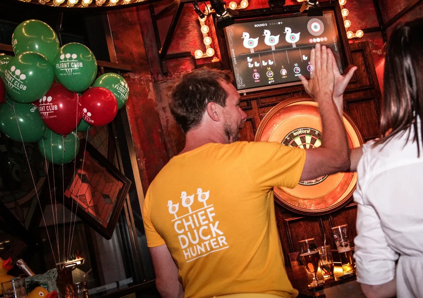 gamesmaster giving a high five at the quackshot games launch at flight club