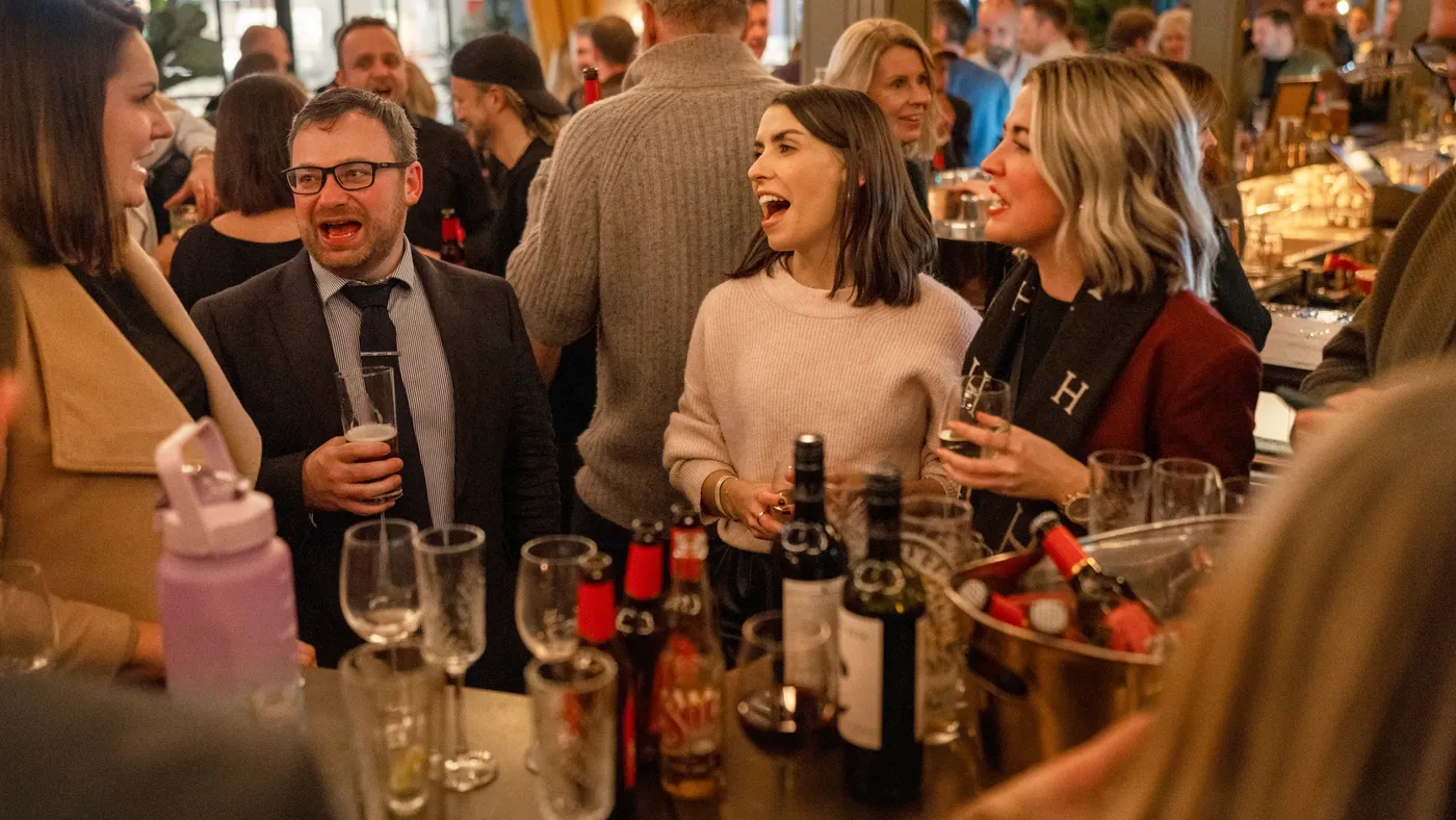A group of people enjoying drinks at a team event in Flight Club