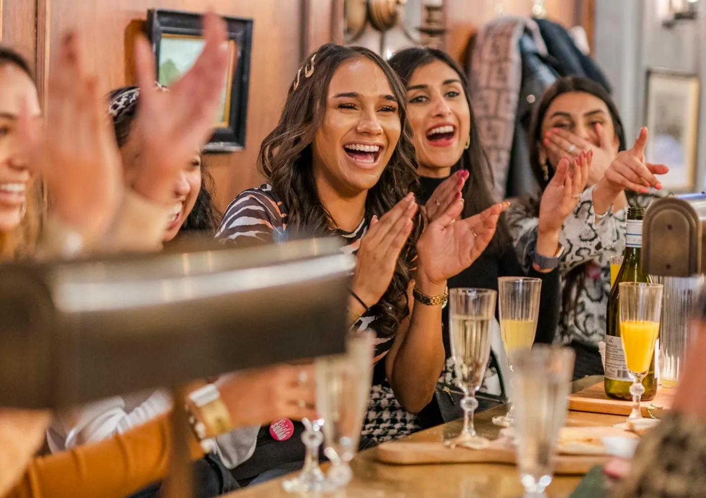 girls laughing at a bar table in flight club