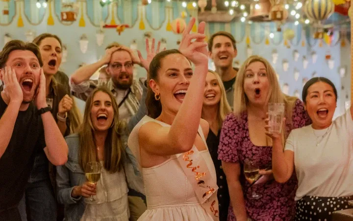 A group of people playing darts at a hen party in Flight Club
