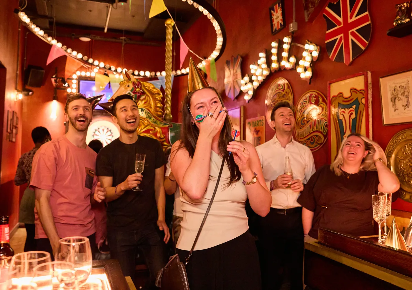 A group of people playing darts at a team event in Flight Club