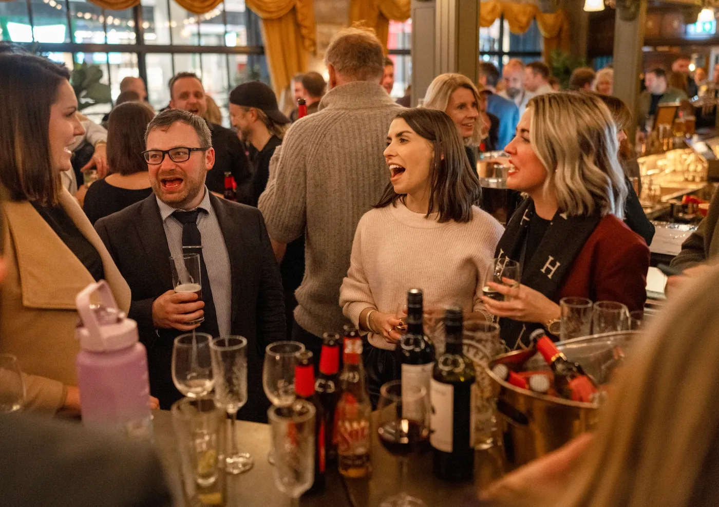 A group of people enjoying drinks at a team event in Flight Club