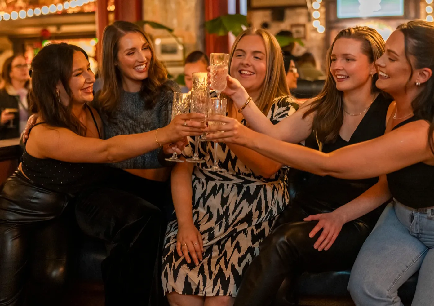girls clinking glasses of prosecco at flight club brunch 