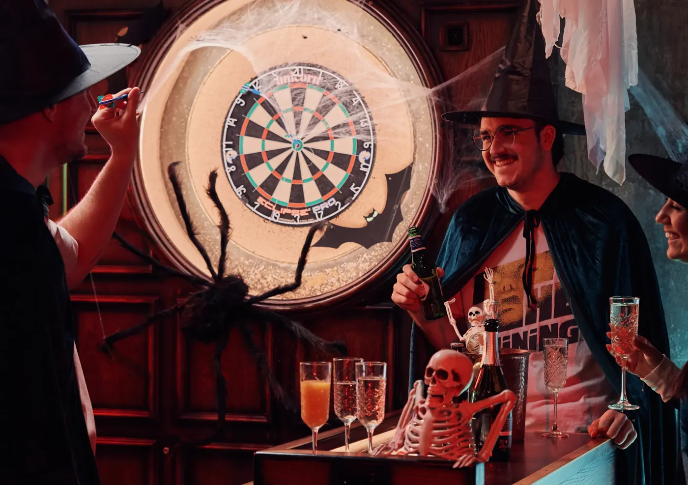 A group of people in Halloween costumes playing Social Darts